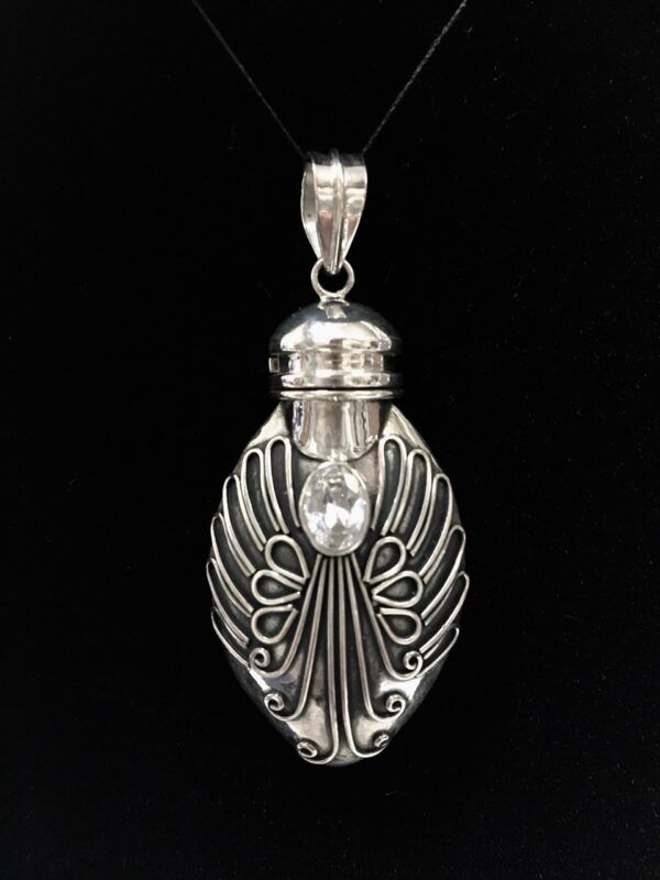 A silver pendant with an angel 's head on it.