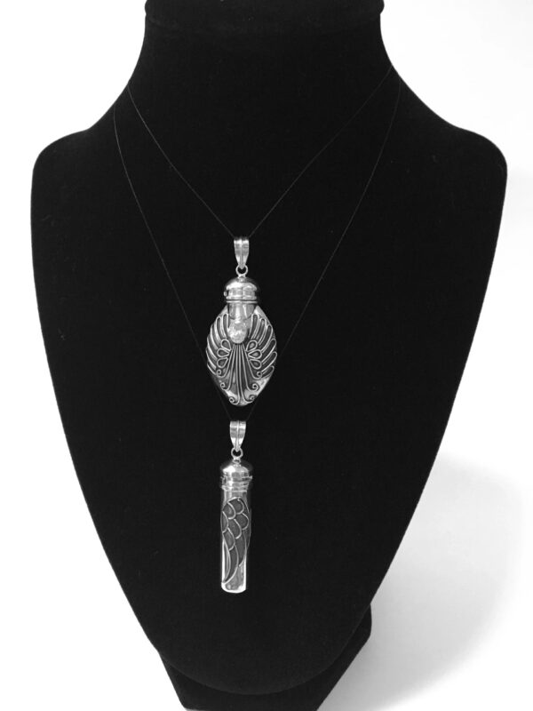 A black velvet display with a necklace and pendant.