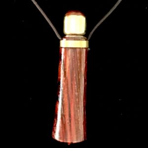 A wooden necklace with a gold top.