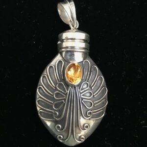 A silver bottle with an angel wing and citrine stone.