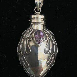 A silver pendant with an amethyst stone in the middle.