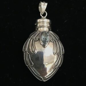 A silver bottle with a blue stone on top of it.