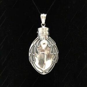 A silver pendant with wings on it